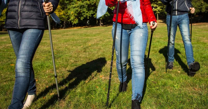 2 Frauen und ein Mann gehen mit Nordic Walking Stöcken